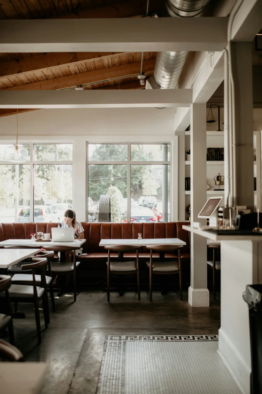 a woman sitting at a table looking out a window