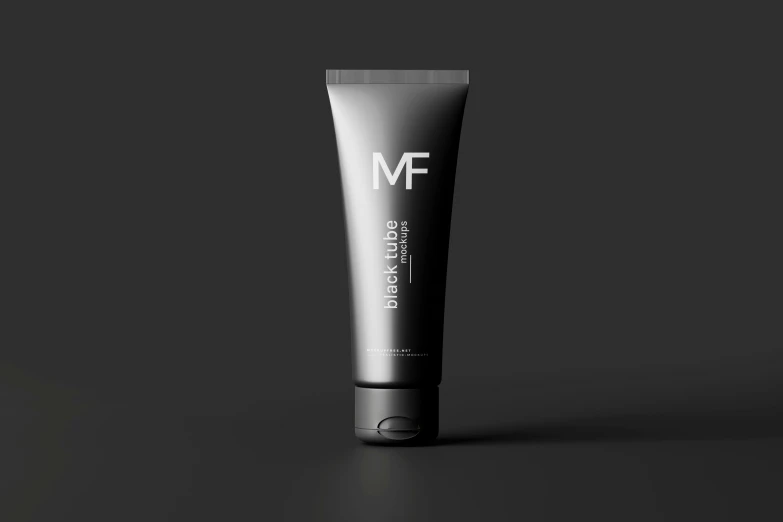 a tube of black - tinted face cream is shown on a dark background