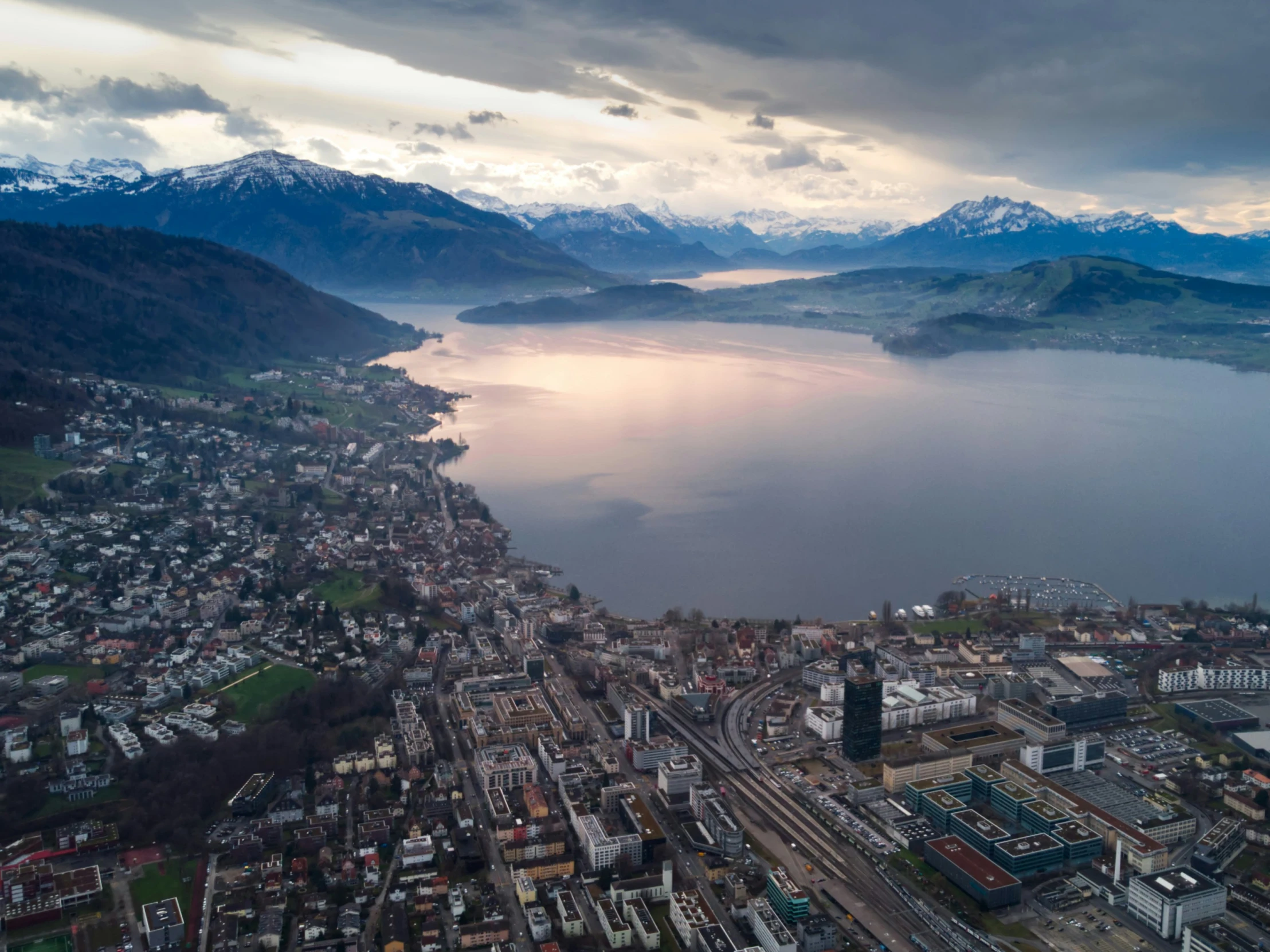 the city with mountains and buildings is surrounded by water