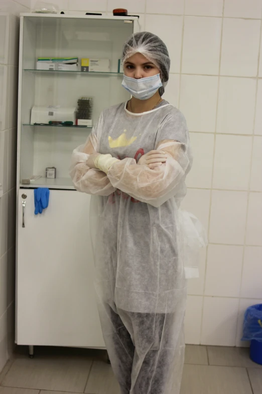 a woman in a room with a plastic disposable outfit on