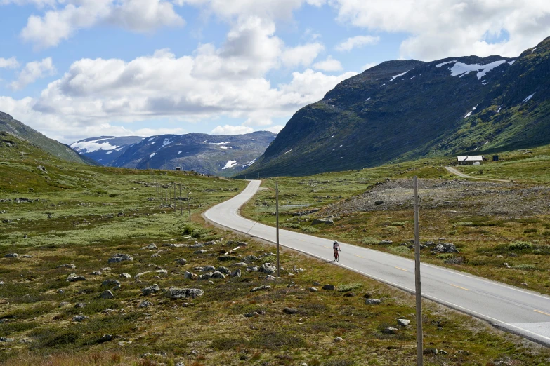 a road winding through a valley surrounded by mountains