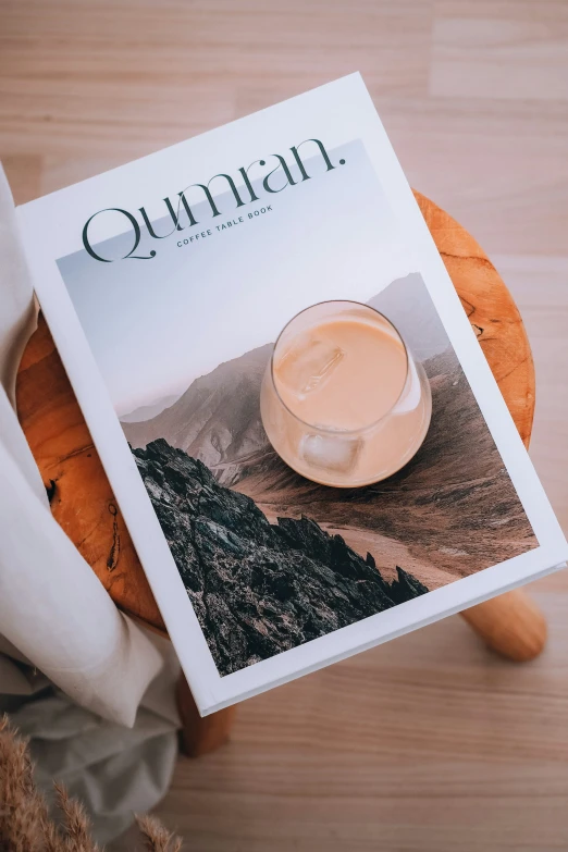 a magazine with a coffee cup sitting on a stool