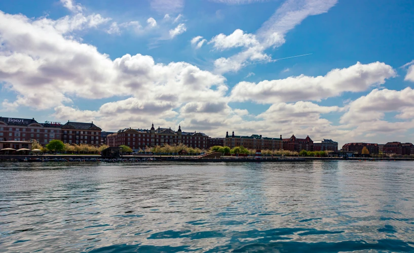 a body of water near a shore with several buildings and trees