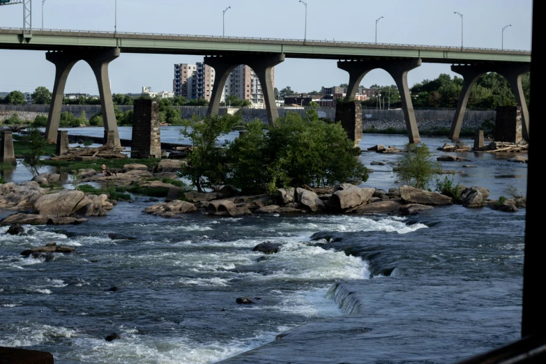 an overpass over a river with rocks and water