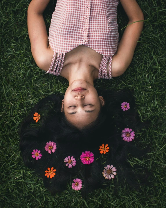 a girl laying on the ground with flowers