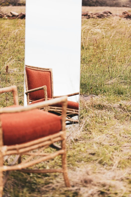 a chair and mirror in a grassy area