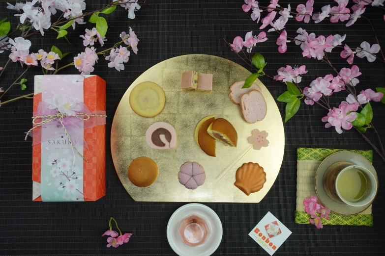 a golden plate on a table with different foods and flowers