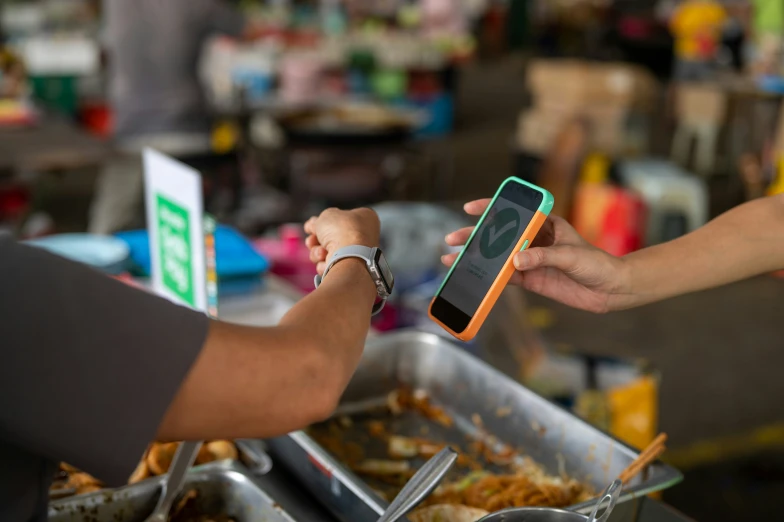 a close up of someone holding an orange and green phone