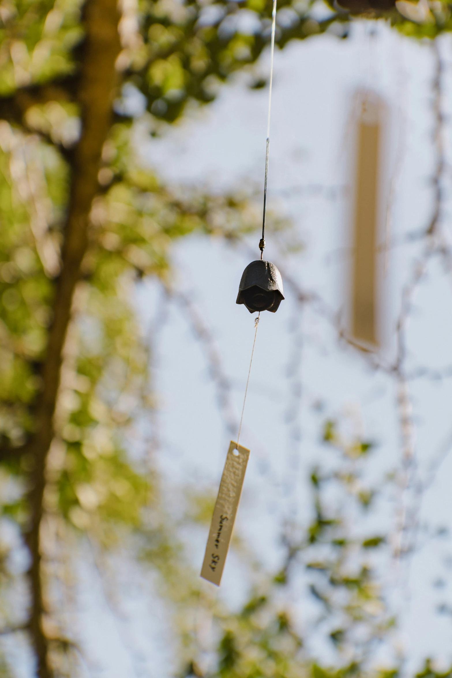 a mobile hanging on a tree outside