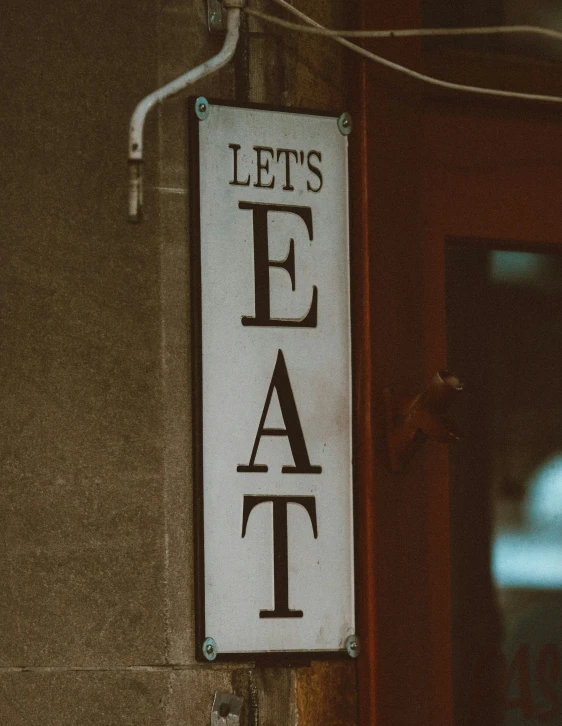 a sign on a pole saying let's eat