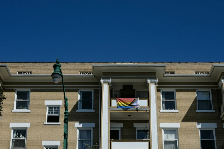 a building with pillars, windows and a rainbow colored flag
