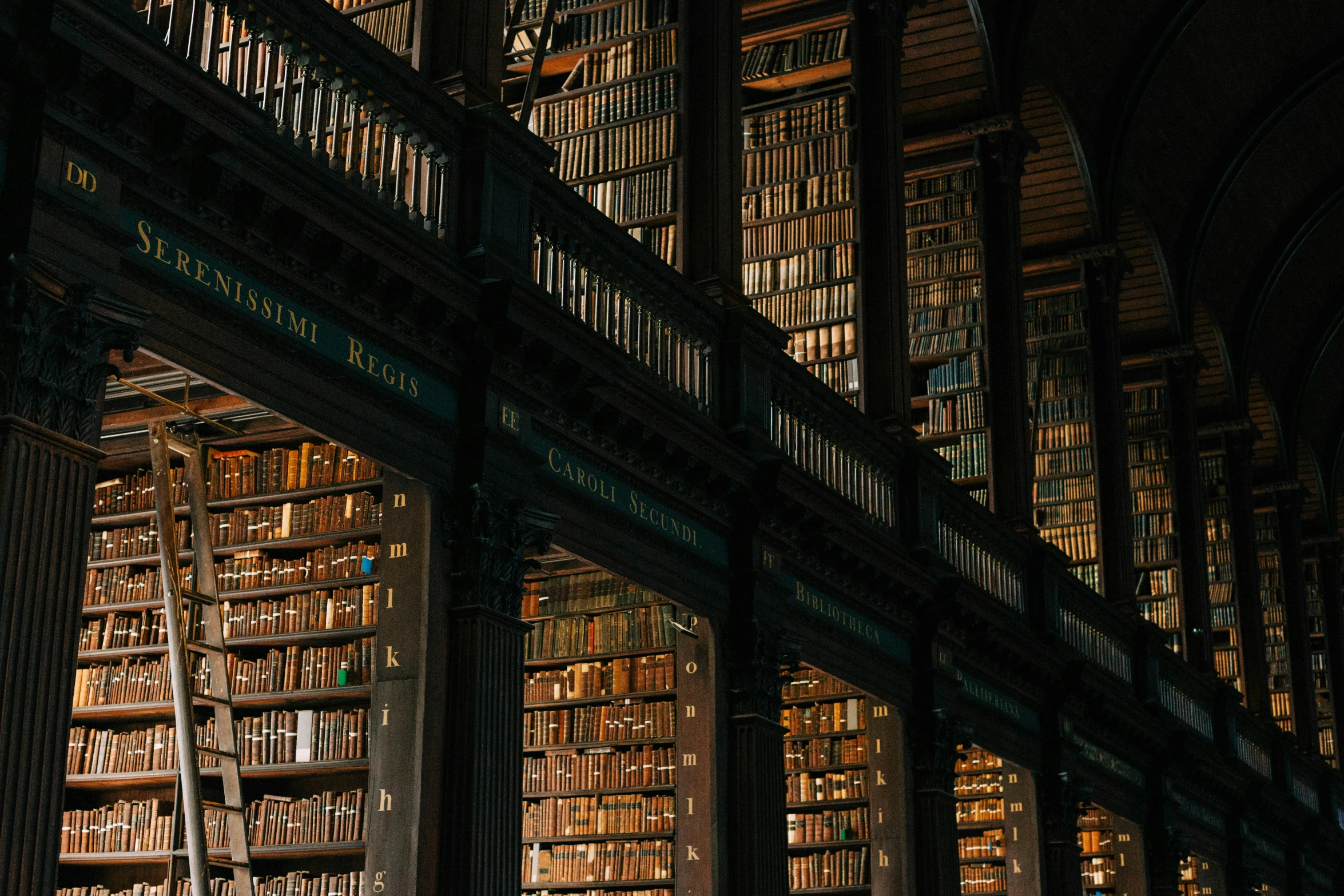 a liry full of books in one room and many shelves filled with books