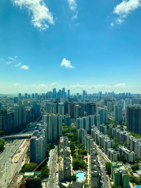 a view from the top of a tall building overlooking a large city with skyscrs and parking lots