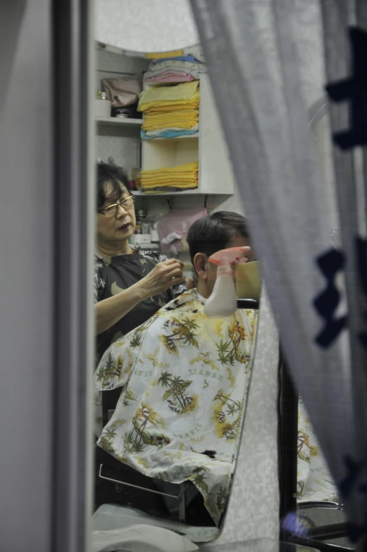 a woman in a room with curtains is getting her hair brushed