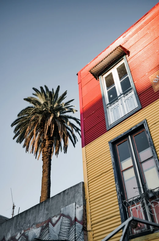 a tall yellow building with an orange roof