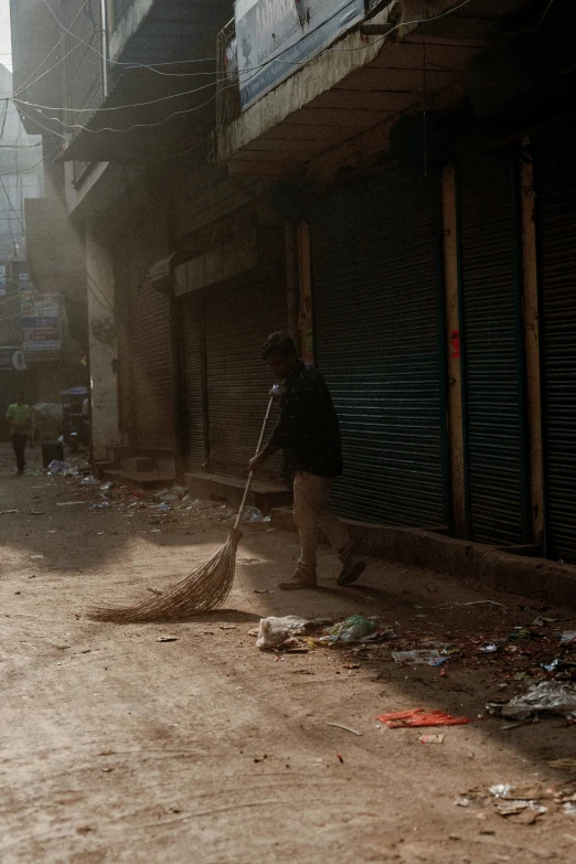 a person cleaning the sidewalk with a mop