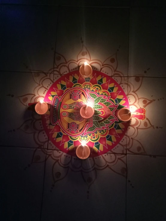 a colorful candle lit plate on the ground