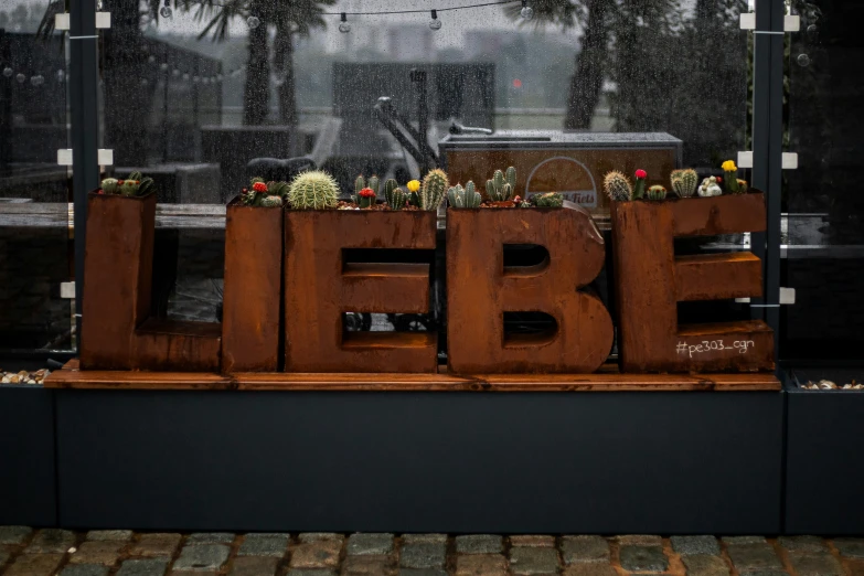 a wooden sign that has plants growing out of it