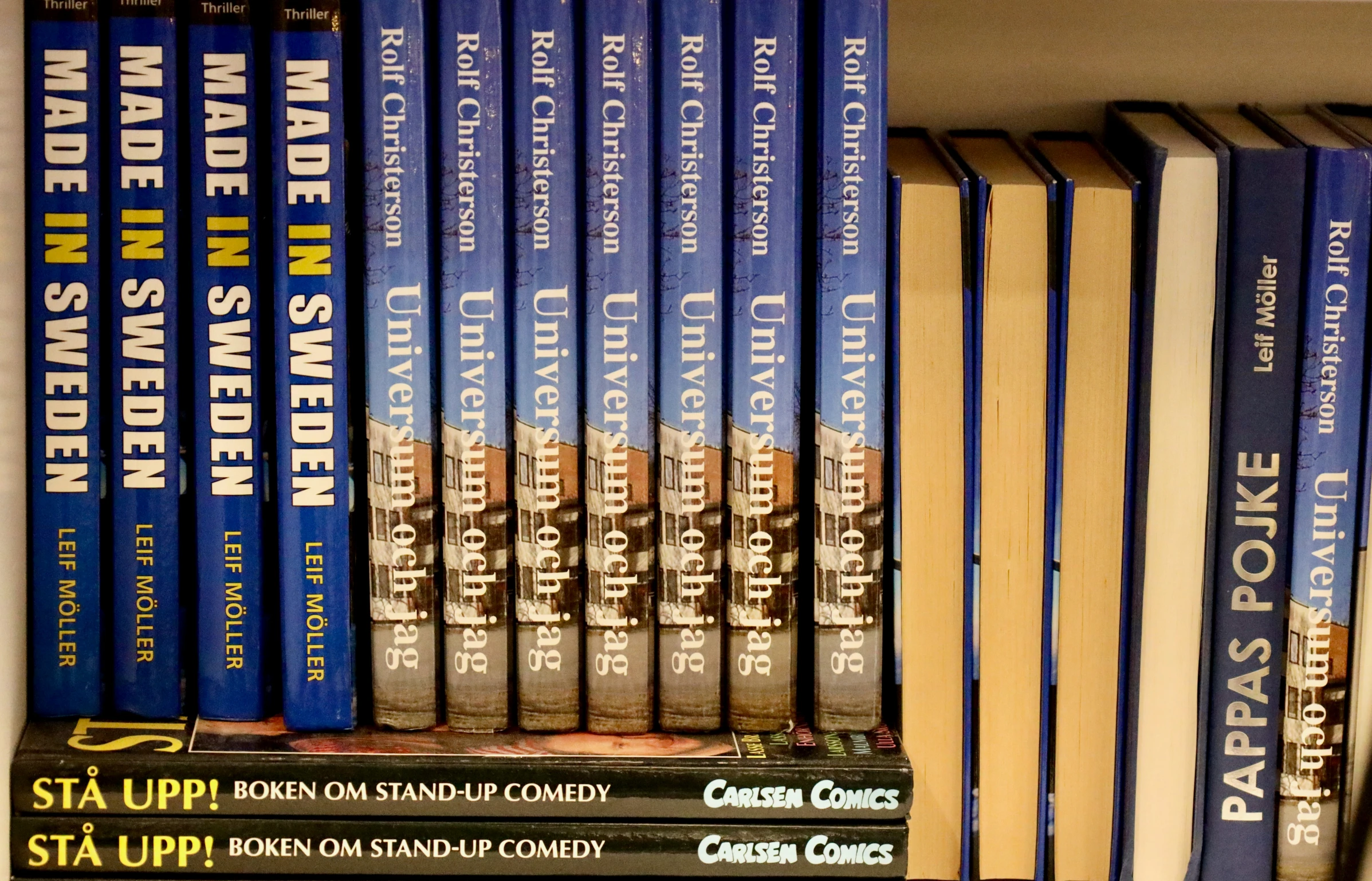 a row of books on a shelf with an empty bookcase