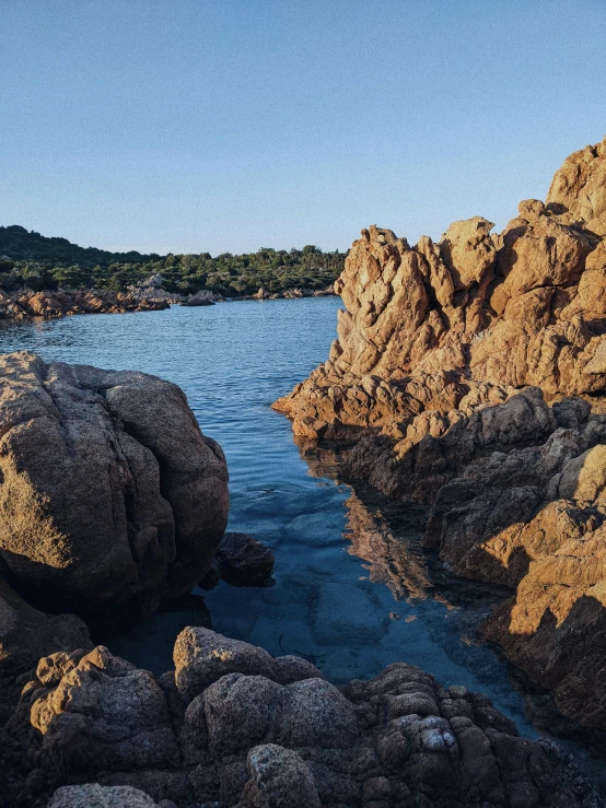 a rock outcropping in the water near the beach