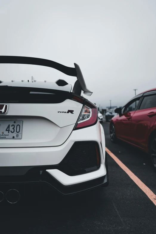 the back of a white honda civic with black and silver stripes