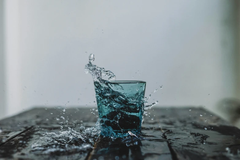 a glass of water is splashing into the air