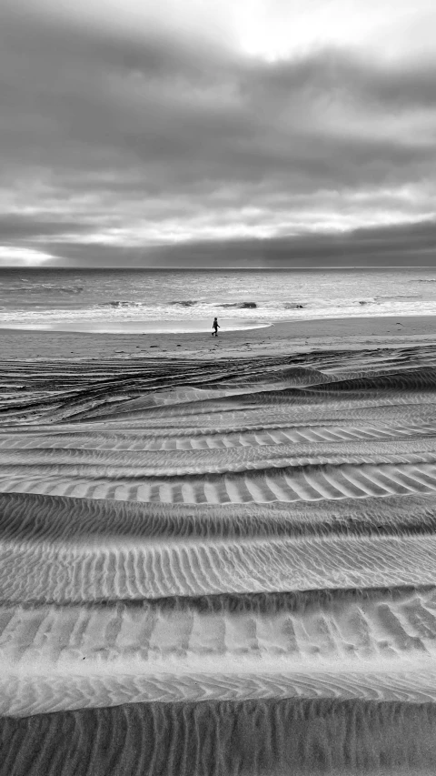 two surfers in the distance walking on the beach