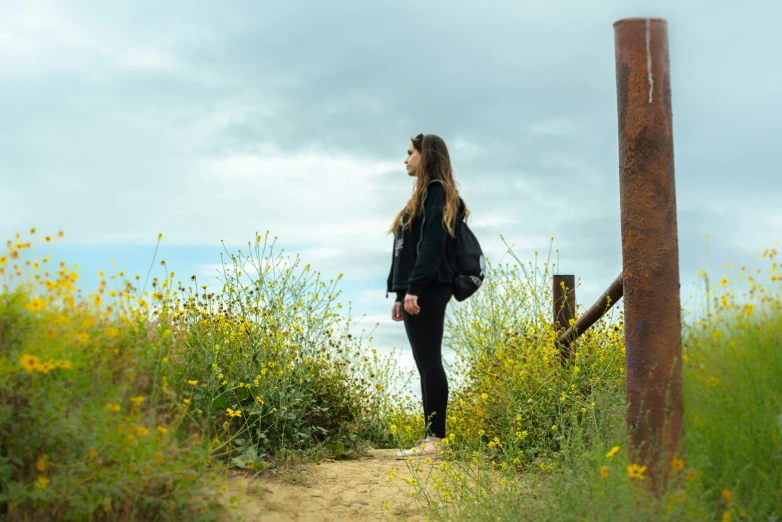 a girl in a black shirt walking down a trail