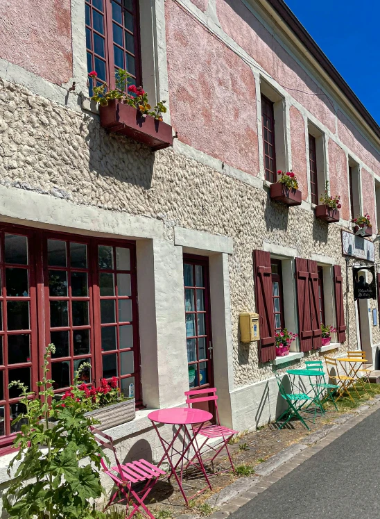 pink tables and chairs outside of an old building