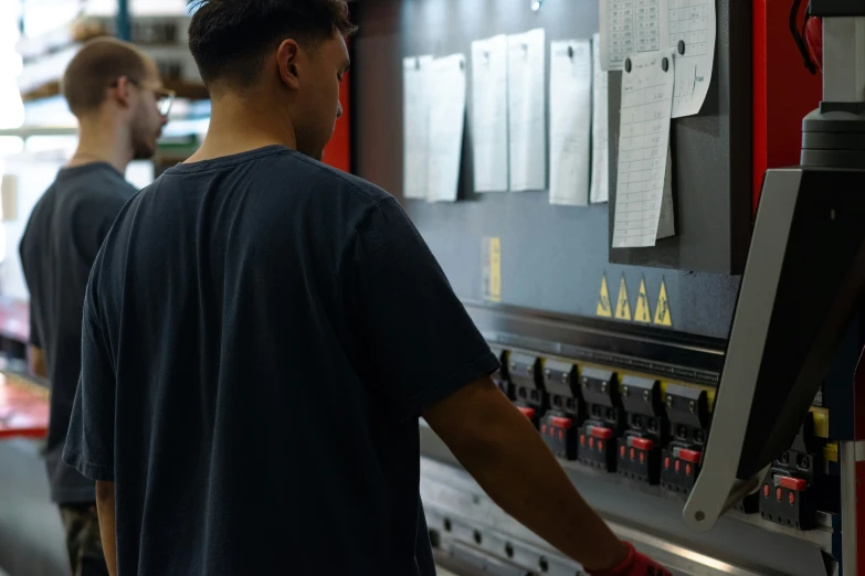 two men working on the machinery in a factory