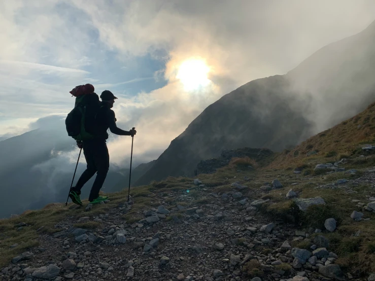 two people hiking on a hillside surrounded by mist