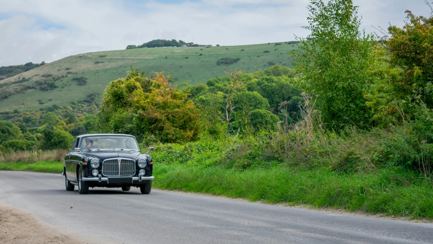 a car is traveling down the country road