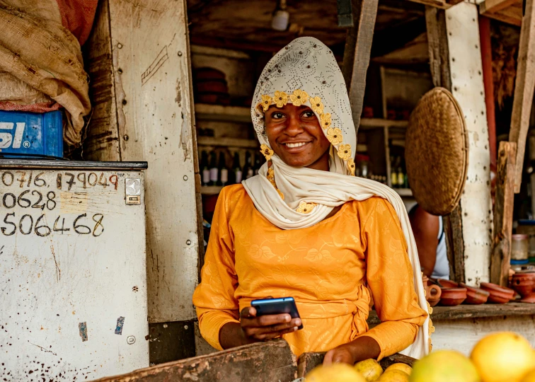 a woman standing in front of a fruit stand with apples and bananas