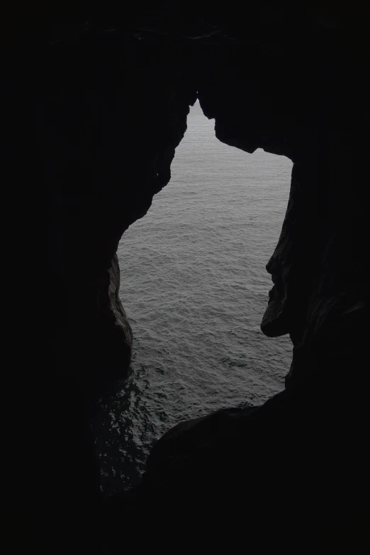 the ocean is dark and calm as a boat sails through a hole