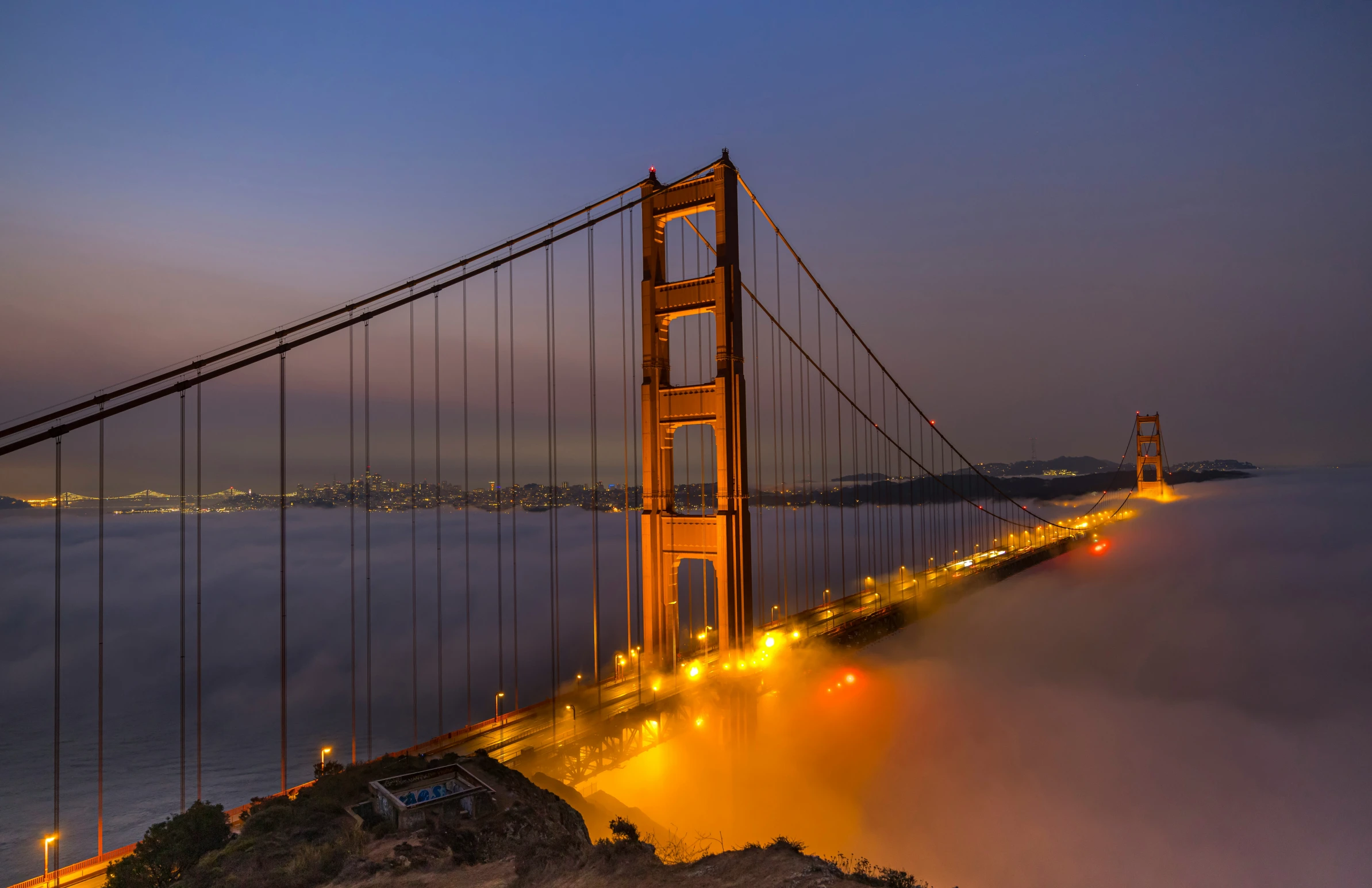 the golden gate bridge lit up on a misty night