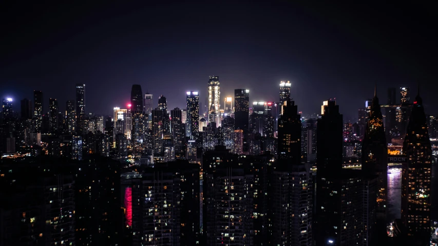 the lights of tall buildings can be seen at night