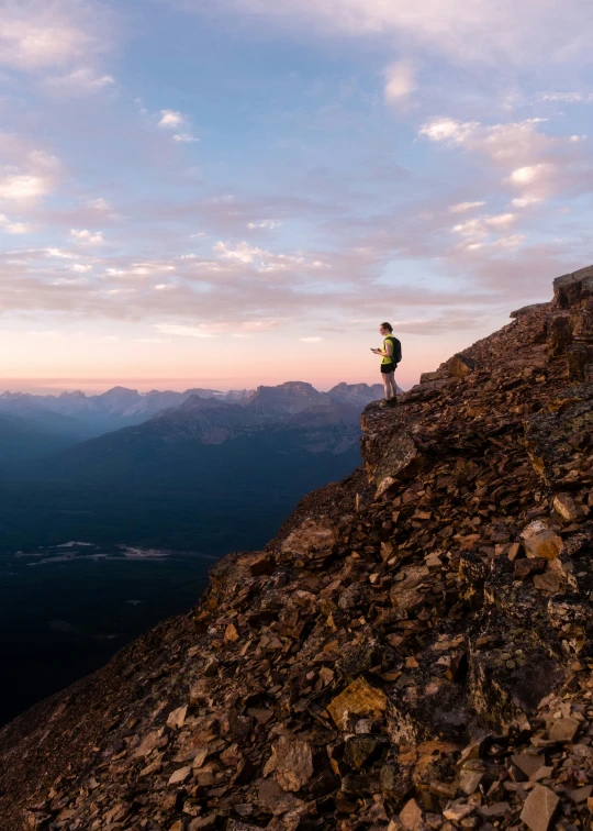 a man standing on the top of a large cliff