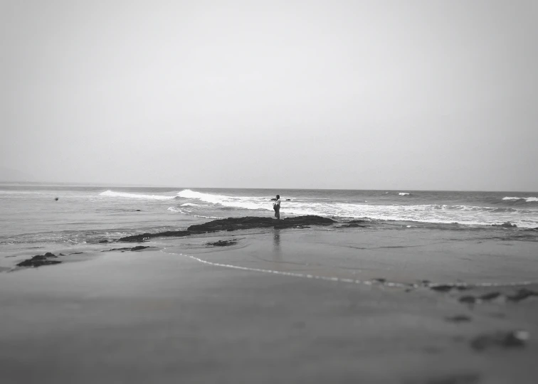 a person standing in the middle of a body of water near an ocean