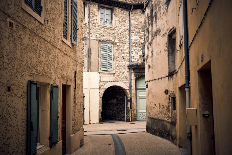 alley with several doors and windows with a light in between