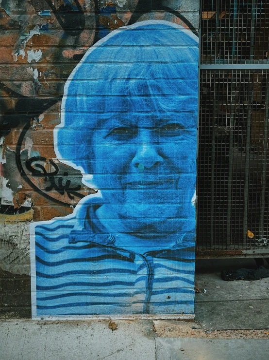 there is a mural on a wall that has an image of a man's face painted in blue