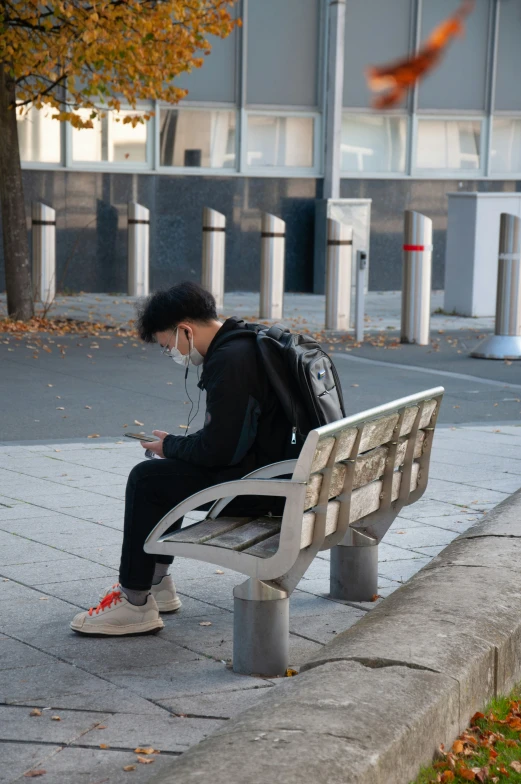 a man sitting on a bench looking at his cell phone