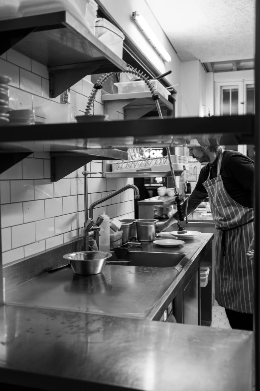 a man is working behind the counter preparing food