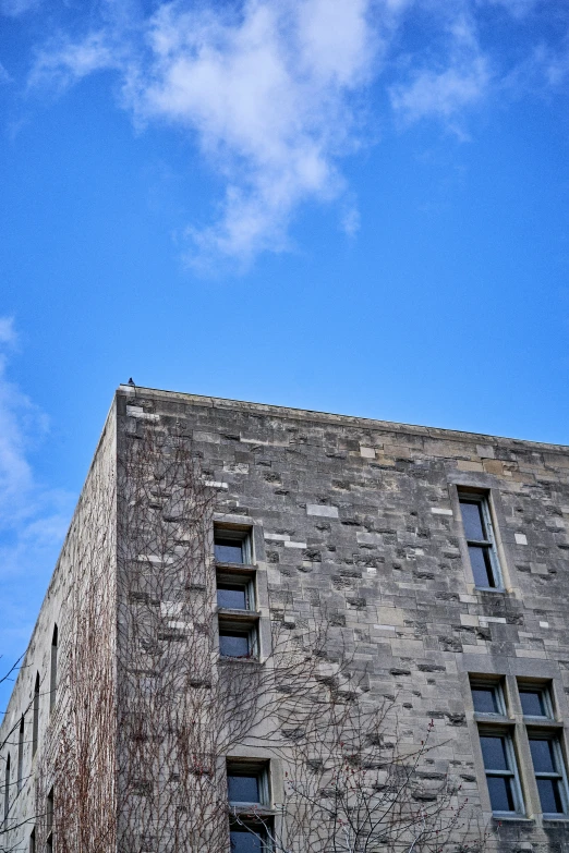 a very tall building with windows under a partly cloudy sky