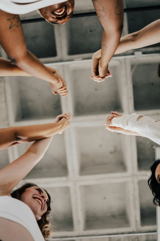 group of people standing in a circle with their hands