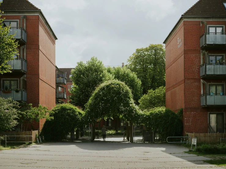 two red brick apartment buildings surrounded by trees