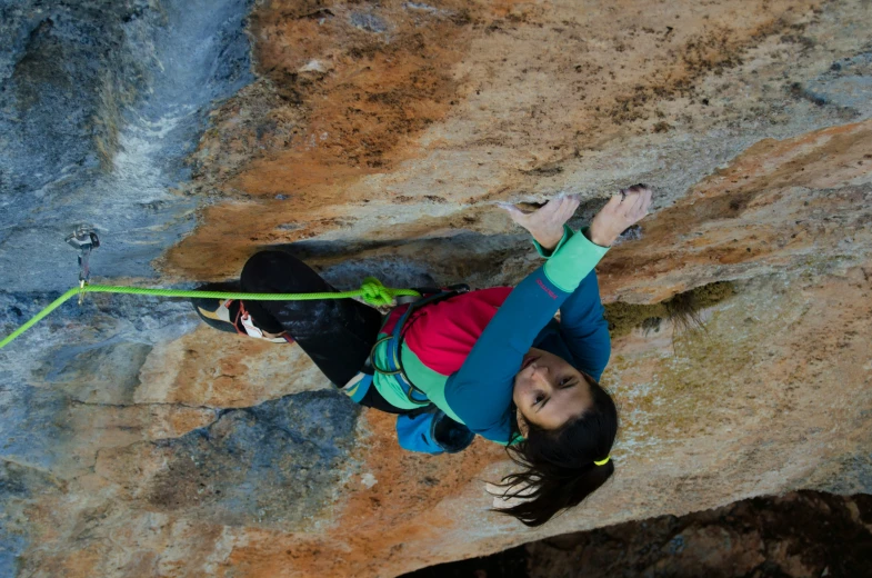 the girl is climbing up the side of a cliff