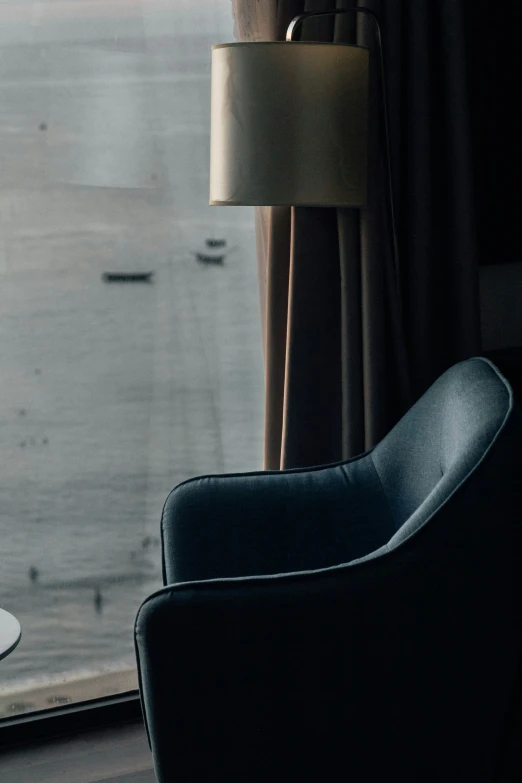 two chairs sitting near a window with rainy water in the background
