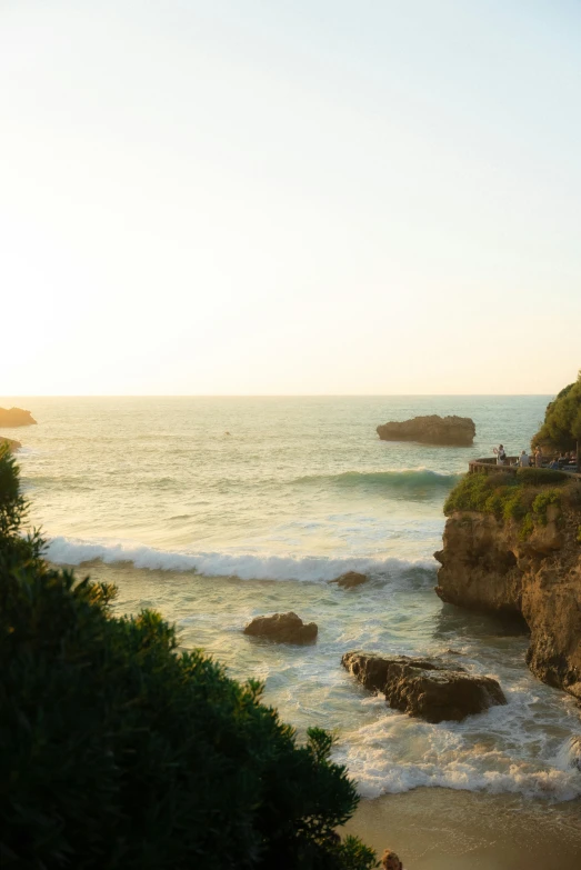 a group of people on shore line watching the ocean