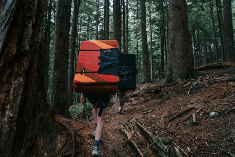 two people in hiking gear with a backpack in the woods