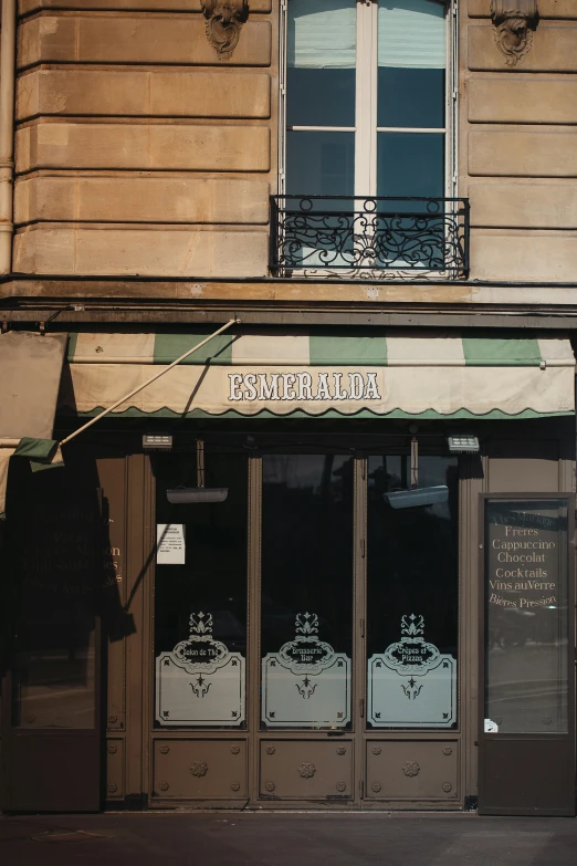 a storefront with a metal balconi over it